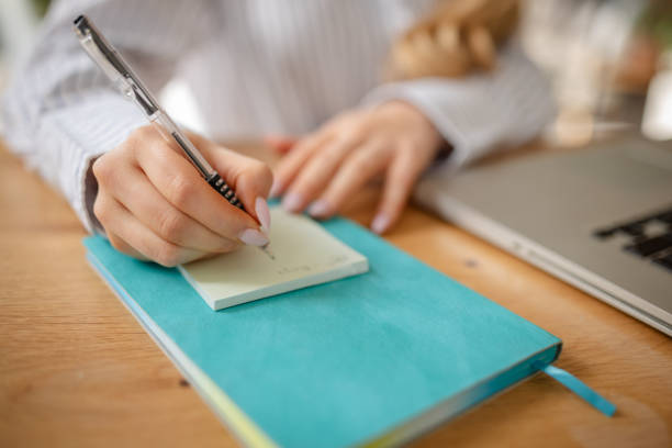 Woman writing to-do list yellow pen. Concept planning and self-management. Top view, above