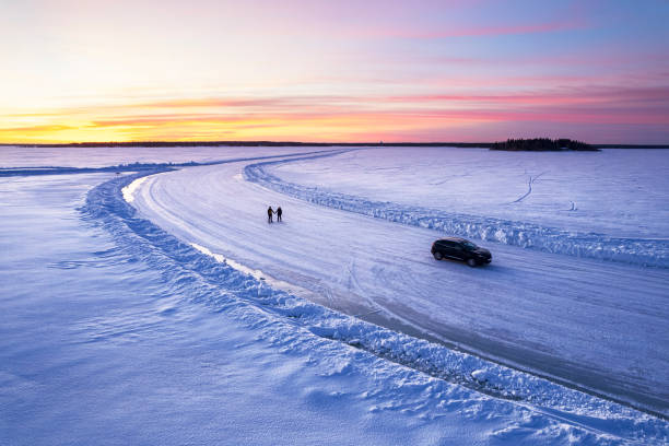 istock Tourists with car on ice road 2199383904