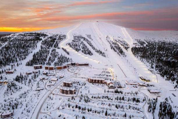 Snowy ski slopes with romantic sky at sunrise, aerial view