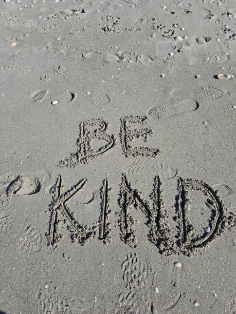 istock Be kind message written in sand on beach vertical photo 2199385747