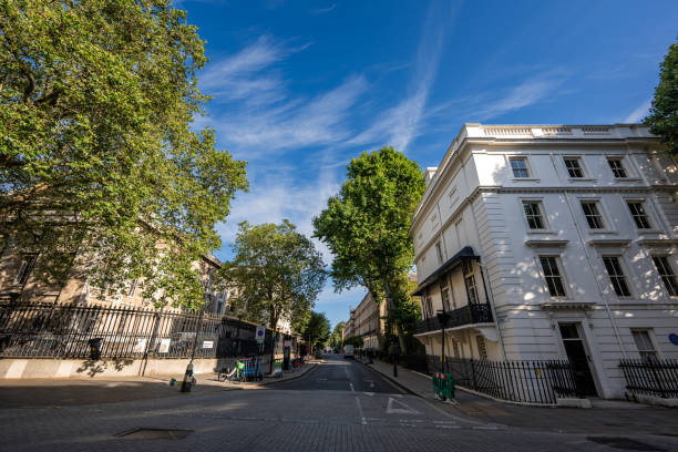 istock A small street in England, surrounded by buildings, fences, and trees, creating a quaint and charming atmosphere. 2199387607