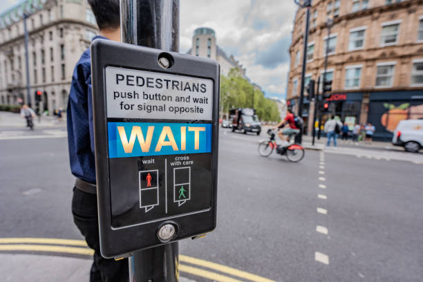 istock a pedestrian signal instructs passersby to WAIT at a lively city intersection, showcasing the vibrancy of urban life with people and cars in motion. 2199387726