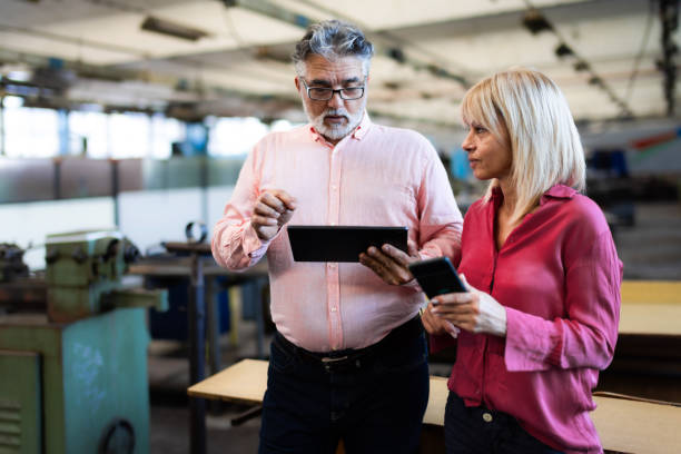istock Two Business Person Walking A Dark Factory  and talking about their latest projects 2199389313