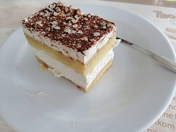 istock Sweet dessert, vanilla cake, slice on white plate with spoon, close up 2199391092
