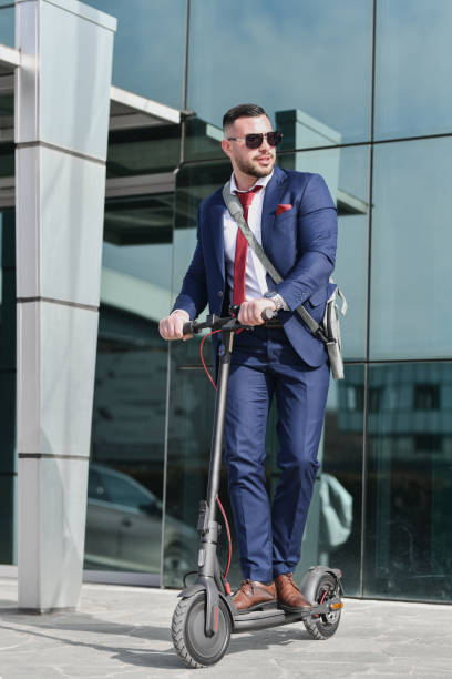 istock Modern Male Executive Riding Electric Scooter While Looking Sideways 2199391186