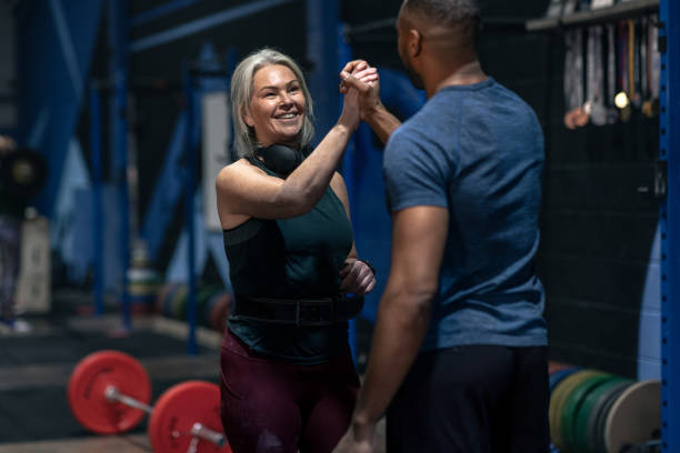 istock Trainer Helping Client Achieve Fitness Goals 2199392119