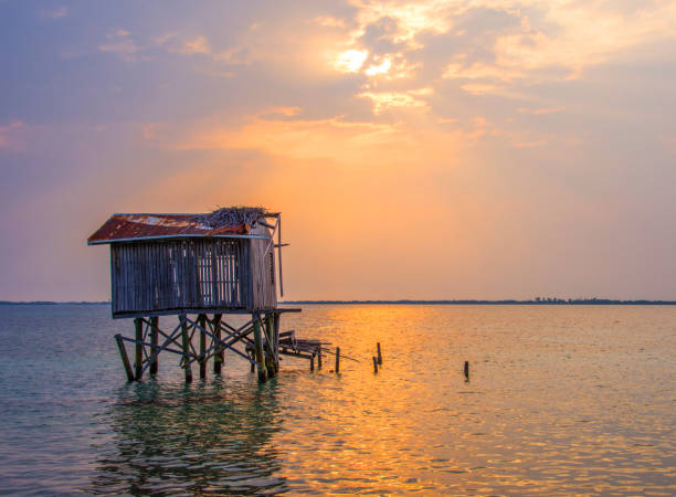 Abandoned shack on stilts at Tobacco Caye off the coast of Belize in the Caribbean Sea. Central America.