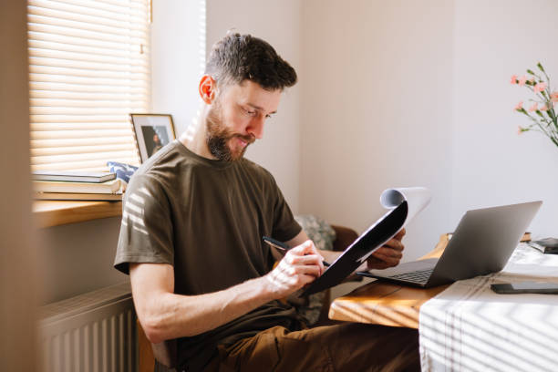 istock Confident Military man sign a document sitting at the domestic kitchen 2199394990