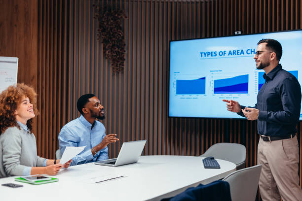 istock Manager presenting company strategy using charts on a monitor during a meeting 2199395071