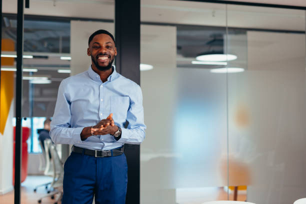 istock Smiling businessman clapping hands in modern office 2199395211
