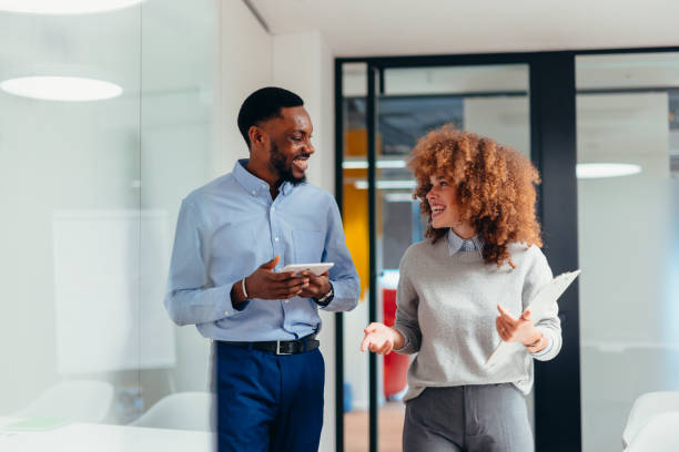 istock Business colleagues walking and talking in modern office corridor 2199395264