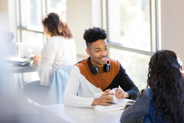 istock Young man and woman studying together in a bright classroom 2199398191