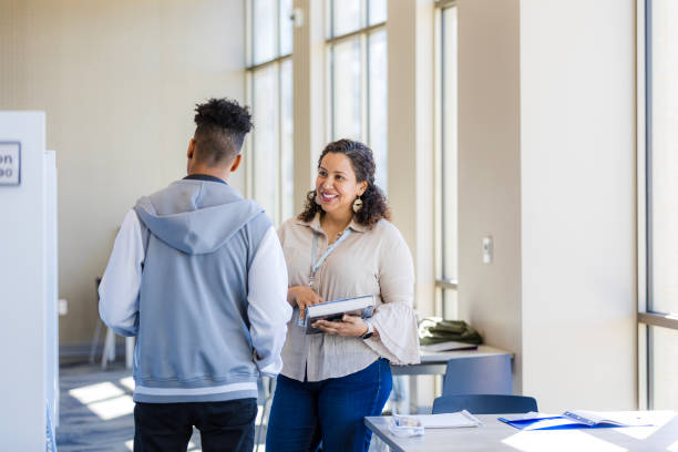 istock Teacher and Student Talking in University Hallway 2199398211