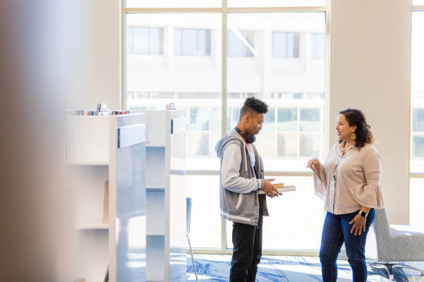 istock Student and Teacher Discussing Books in a Library 2199398216