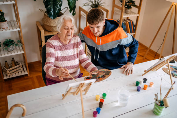 istock Enjoying spending time with older people and talking to them while painting together 2199398715