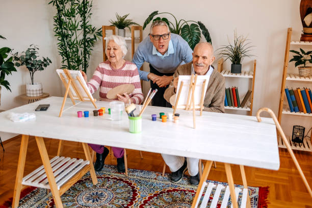 istock Enjoying spending time with older people and talking to them while painting together 2199398770