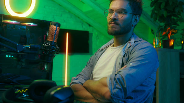 istock Emotional angry failure upset streamer take off headphones lost bad result problem sad play video game Caucasian man trouble male guy computer gamer cyber stream talking microphone at home dark neon 2199400355