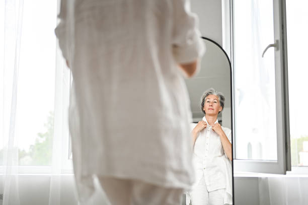 istock Senior woman checking herself in the mirror at home 2199403706