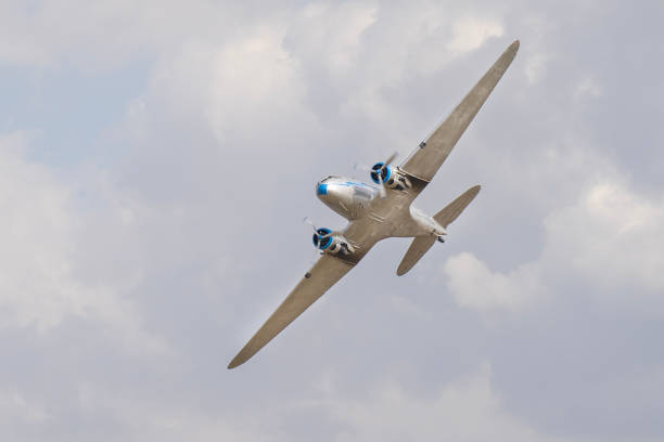 istock Vintage twin engine propeller plane flying in the cloudy sky 2199404122