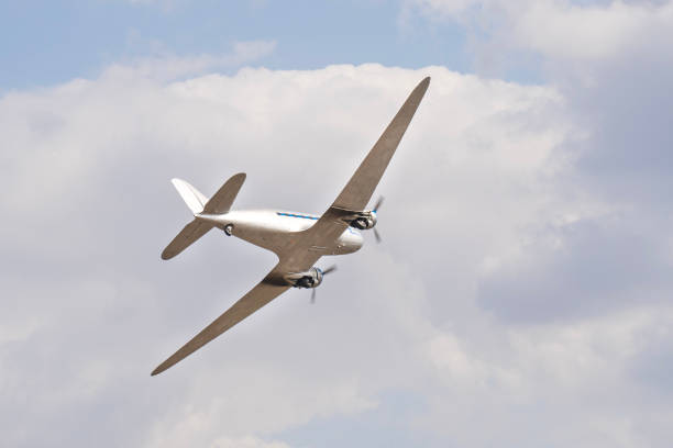 istock Vintage twin engine propeller plane flying in the cloudy sky 2199404130