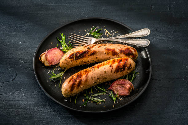 Two grilled sausages ready to eat served in a black plate