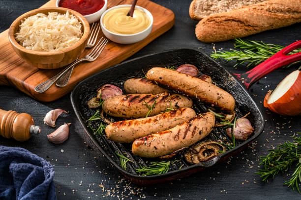 istock German food: cooked Bratwurst sausages in a grill pan, sauerkraut and mustard 2199404675