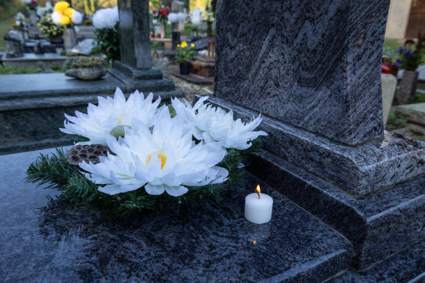 istock Grave with white flowers and a white candle. 2199406293