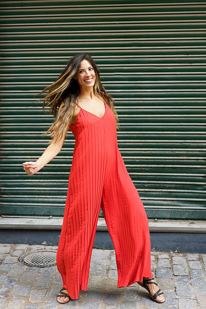 istock A vibrant red jumpsuit featuring a dynamic dance pose set against a lively green background 2199407744