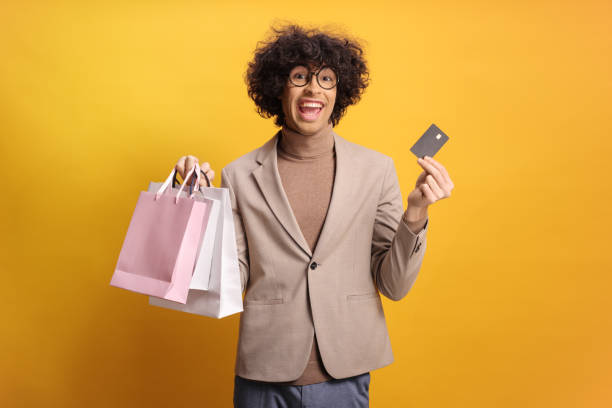 istock Young man holding shopping bags and a credit card 2199408024