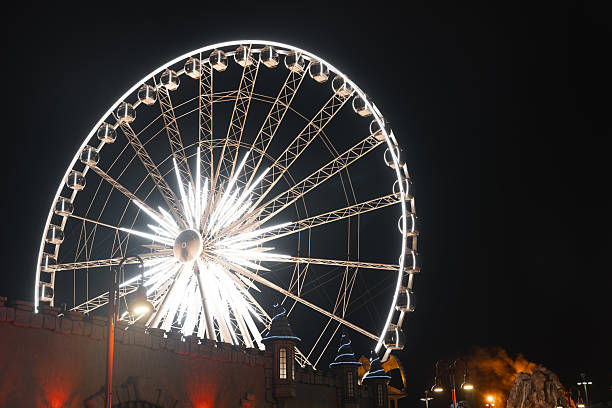 istock Shiny Ferris wheel in an amusement park at night 2199411584