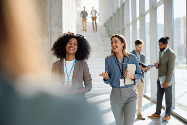 istock Happy businesswomen talking while walking through a hallway. 2199415156