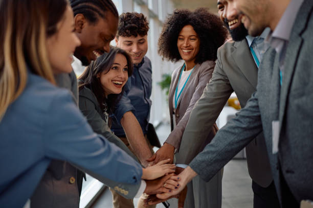 istock Multiracial business team gathering hands in unity in the office. 2199415590
