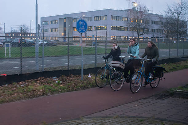 Three girls riding bicycles on a cycle path in North Brabant. The Netherlands. December 12, 2024