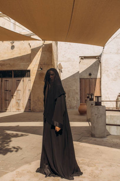 istock Person in Black Veil Standing in a Deserted Architectural Courtyard 2199421073