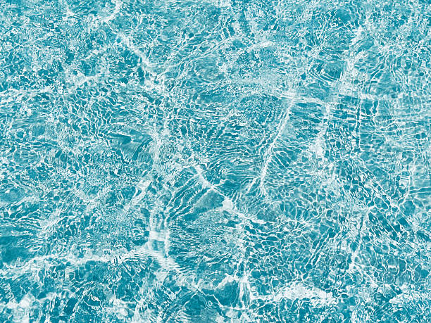 istock Bright sun reflections on calm, clear aqua water background 2199421983