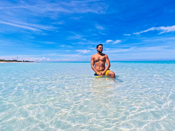 istock Latin man sunbathing in clear blue water at Varadero Beach, Cuba 2199422885
