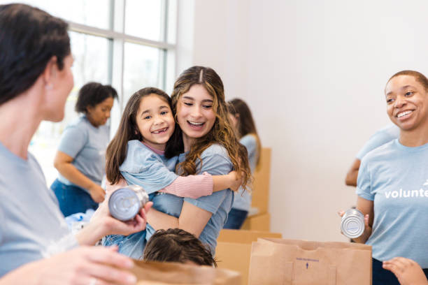istock Smiling woman hugs child during volunteer work 2199422948