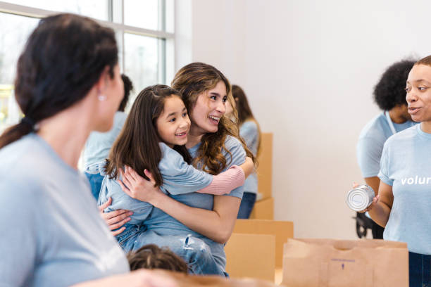 istock Happy Volunteers Embracing a Child During a Charity Event 2199422950