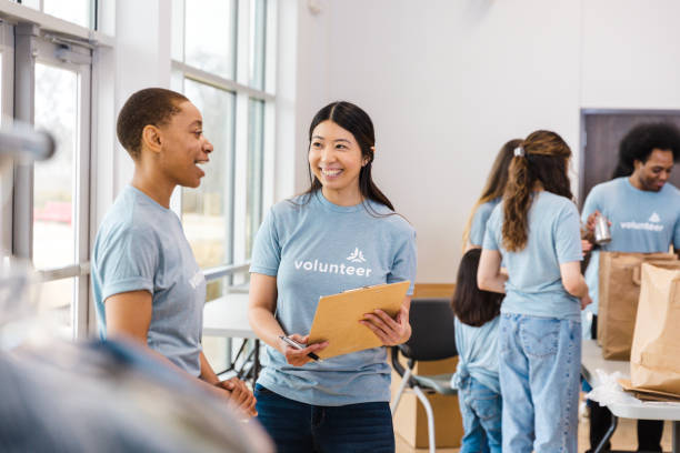 istock Smiling Volunteers Working Together at a Charity Event 2199422956