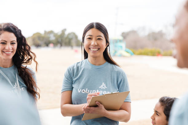 istock Smiling Female Volunteer Using Clipboard Outdoors 2199422964