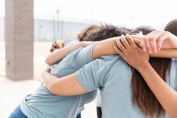 istock Group of diverse women embracing in a supportive hug 2199423497