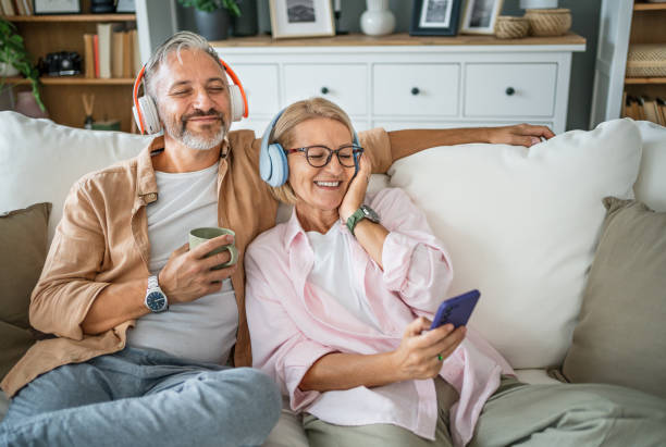 istock Mature couple enjoying music while relaxing at home 2199429544