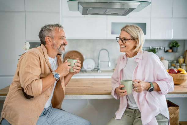 istock Mature couple drinking coffee together in the kitchen 2199430984