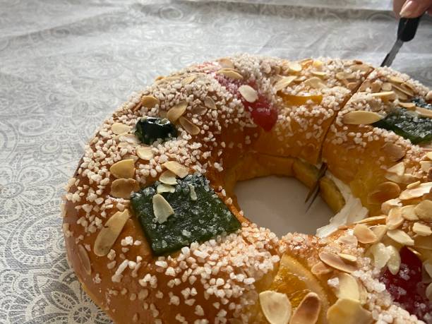 istock Traditional Roscon de Reyes Cake with Candied Fruit, Almonds, and Sugar Topping Being Sliced 2199435361