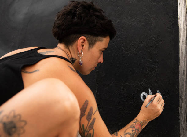 Young female artist signing his artwork on a mural - Buenos Aires - Argentina