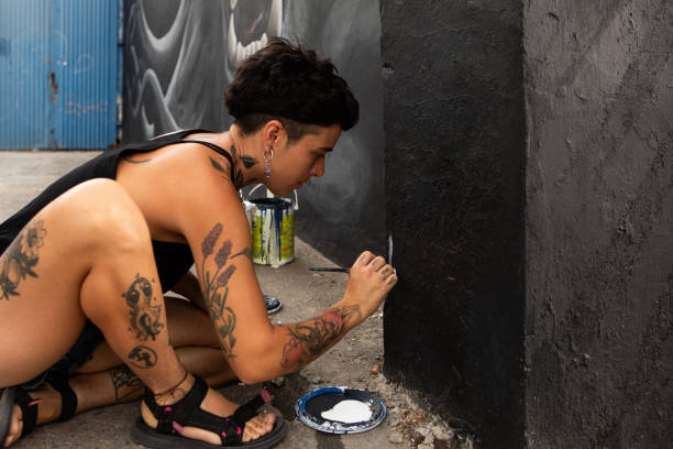 Young female artist signing his artwork on a mural - Buenos Aires - Argentina