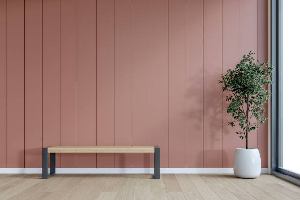 istock A minimalistic interior with a wooden bench and potted plant in front of an empty dusty terracotta / muted clay paneled accent wall background with copy space, window and decoration 2199445577