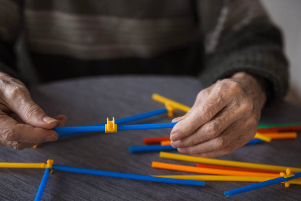 istock Elderly man playing with straw flexible block game set 2199450038