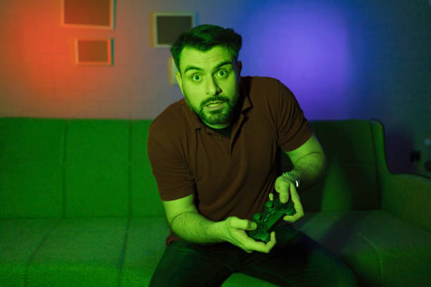 Excited gamer playing video games at home in a colorful room