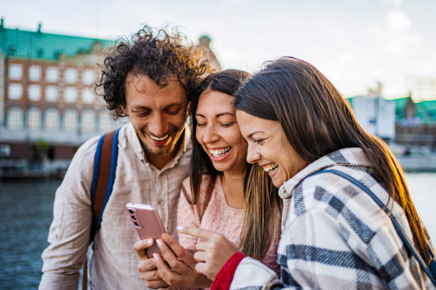 istock Tourists laughing while looking at smartphone in Copenhagen, Denmark 2199450745